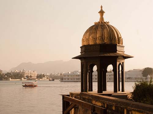 building brown dome gazebo in front of body of water dome