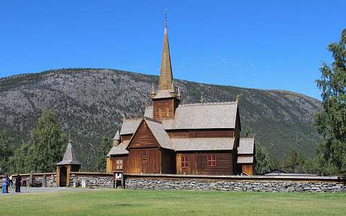 spire brown wooden house near mountain tower