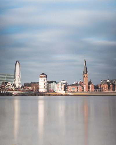 building city buildings by the ocean under white clouds spire