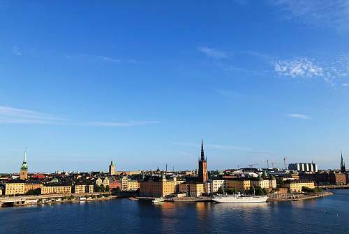 building city buildings near body of water under blue sky spire