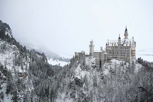 building gray concrete building on mountain covered with snow castle