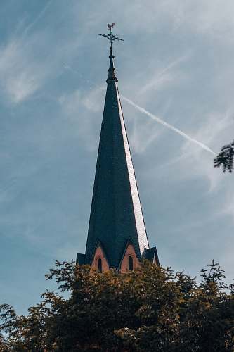 building grey church beside tree spire