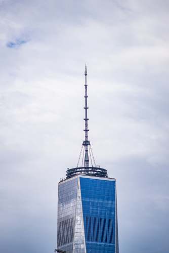 spire grey communication tower on top of blue and grey building tower