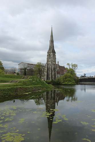 building grey concrete building near pond spire