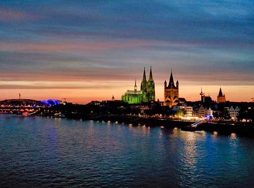 building lighted city buildings near body of water spire