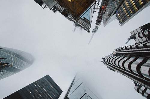 building low angle photo of high rise building covered with fog city