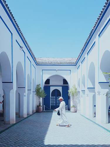 building man walking inside white temple during daytime dome