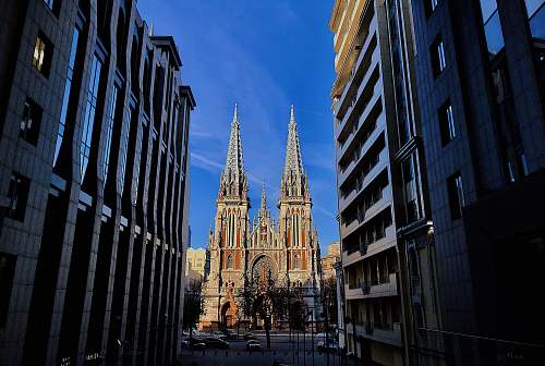 building narrow road in between buildings at daytime spire