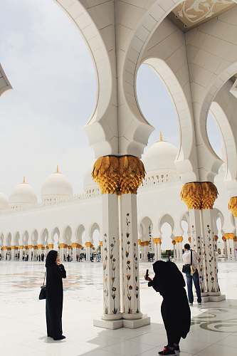 building person taking picture of woman wearing abaya and hijab during daytime dome