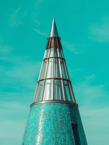 building photo of pointed tower across blue sky tower