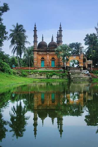 building photography of brown mosque beside body of water during daytime dome