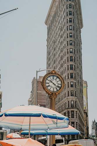building round analog clock near Flatiron building at New York during daytime tower