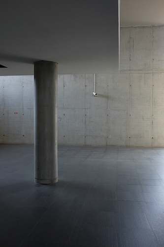 building The inside of a building made of concrete walls with a platform supported by pillars. grey