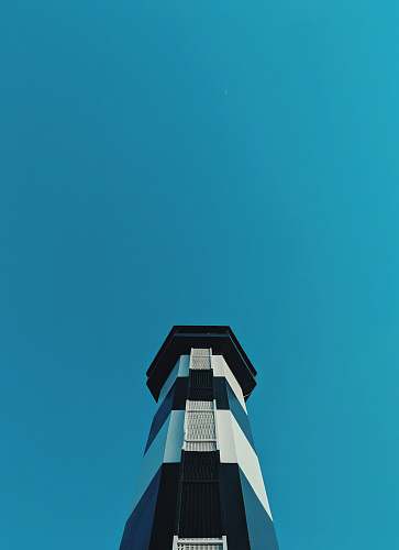 building white and blue lighthouse in low-angle photography during daytime tower