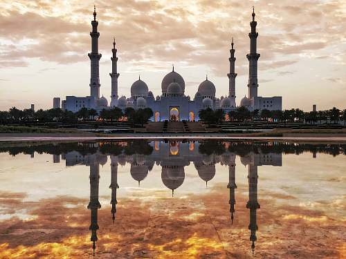 building white and gray mosque in front of body of water dome