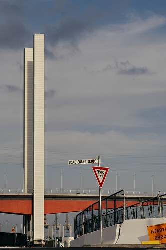 building white and red bridge under gray clouds tower