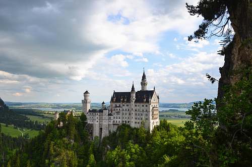 building white castle surround by green trees during daytime castle