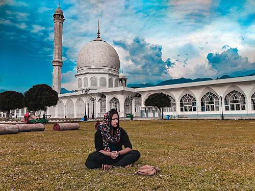 building woman wearing gray hijab sitting in front of dome building dome