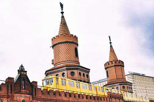 spire yellow train beside castle building