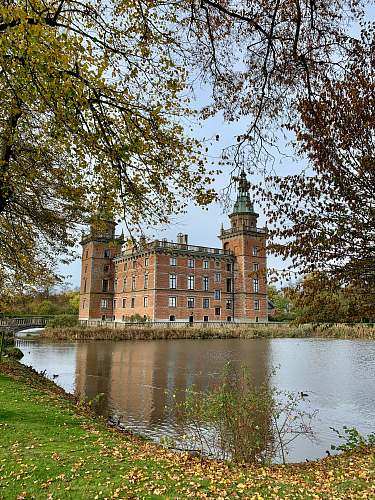 architecture brown concrete castle and green leafed trees near body of water castle