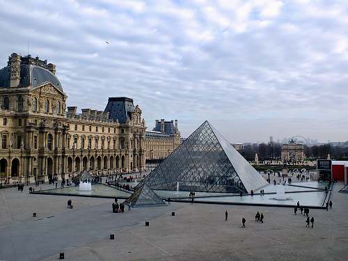paris glass structure beside brown building pyramid