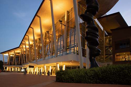 architecture lighted white and brown concrete buildings with glass wall convention center