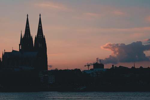 architecture silhouette photography of church under cloudy sky during daytime spire