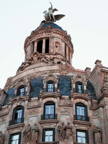 architecture winged human figure statue on top of building dome
