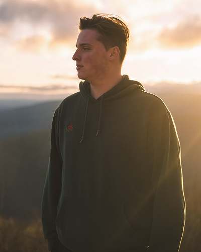 clothing man in black hoodie standing on hill during daytime human