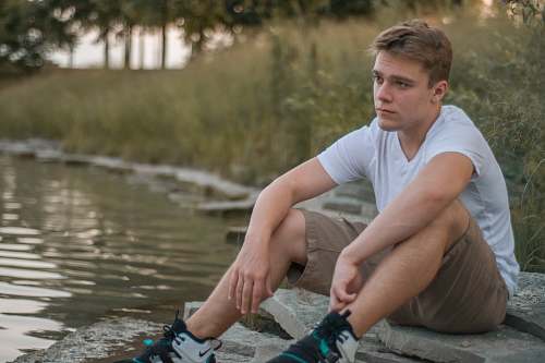 clothing man sitting near water person