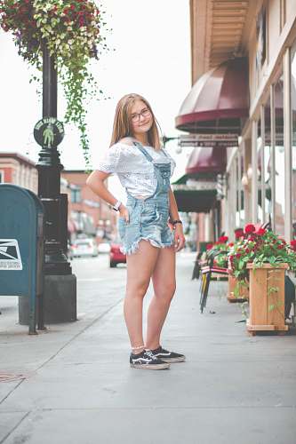 clothing standing woman wearing blue denim romper beside red flowers shorts