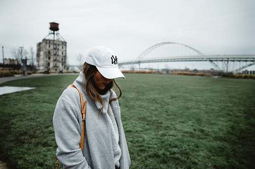 clothing woman in grey sweater looking down at daytime hat