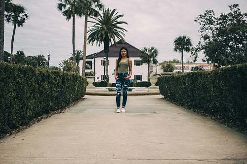 clothing woman standing between hedges footwear