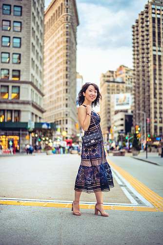 clothing woman standing in center of street near buildings skirt