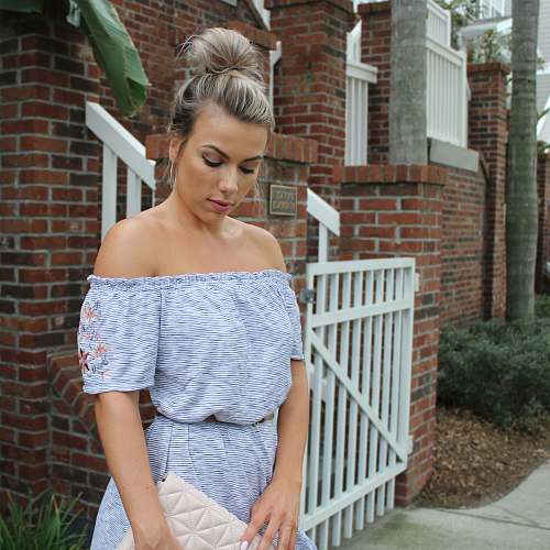 clothing woman standing near wooden fence of house fashion