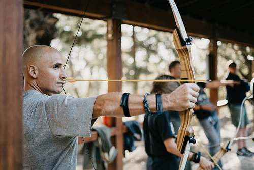 bow man using a brown bow sport