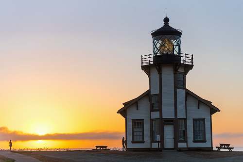 building white and brown lighthouse tower view during sunset tower