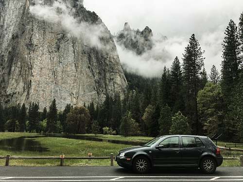 transportation gray 5-door hatchback on the road near trees and mountain car