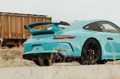 car teal sedan beside trailer truck vehicle
