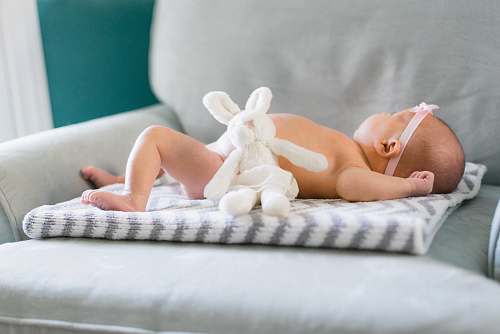 newborn baby on white and gray mat child