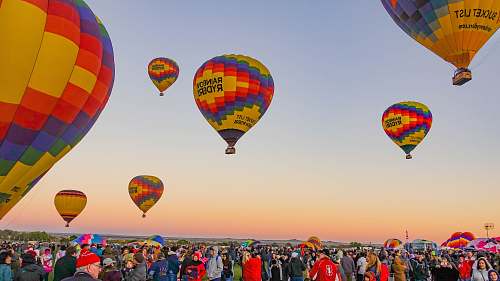 sphere people gathering below multicolored hot air balloons ball