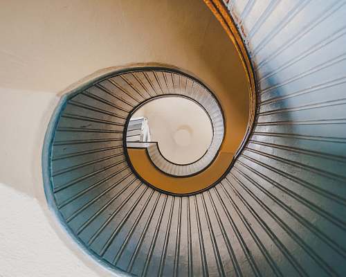 handrail low angle photography of spiral ladder staircase
