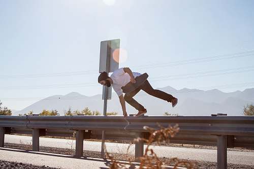 jump man crossing on road fence while holding black skateboard utah lake