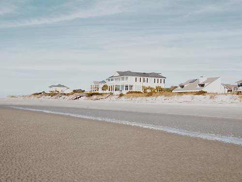 sea white and gray wooden house near road ocean