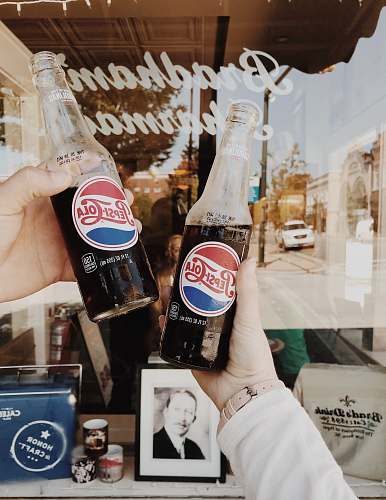 coke person holding Pepsi Cola soda bottles drink