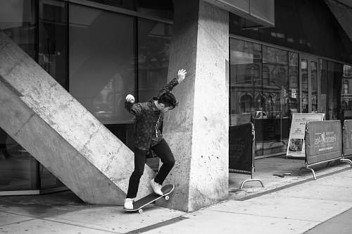 skateboard grayscale photo of man doing skateboard tricks person