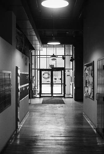 corridor grayscale photography of empty hallway flooring