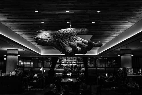 human grayscale photography of restaurant with 3D hand ceiling person
