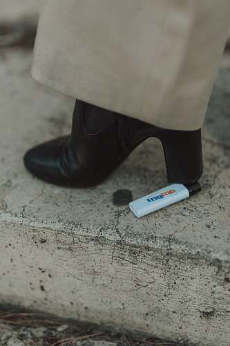 footwear person stepping on white disposable lighter clothing