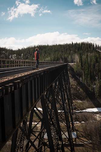 bridge man looking up standing on bridge during daytime building